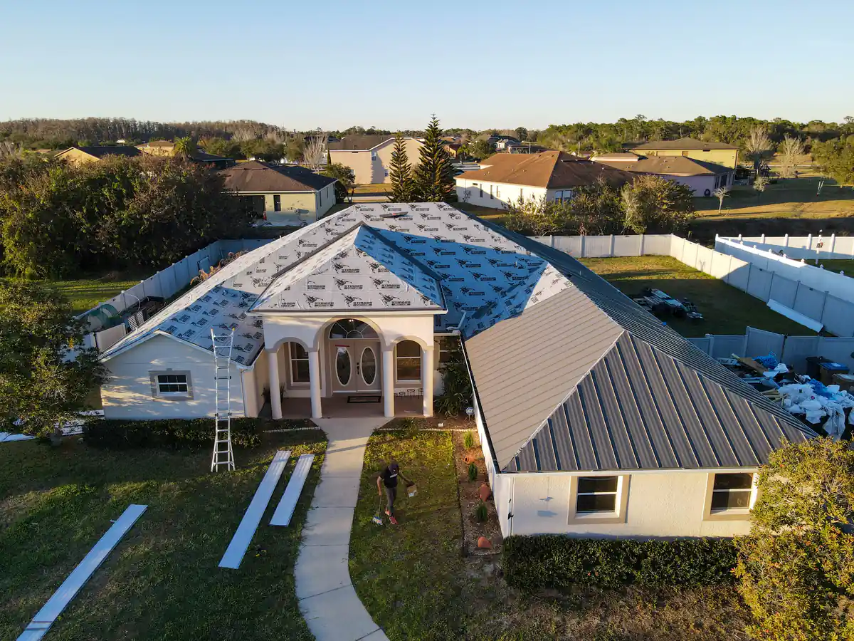 The Kissimmee home part way through the install, with the main roof under underlayment and the wing already in grey panels