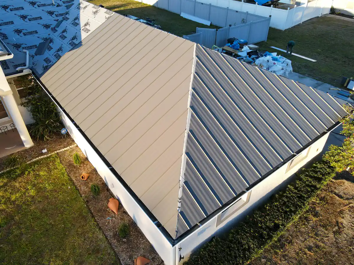 Finished grey panels on one wing of the Kissimmee roof while the main house waits under underlayment