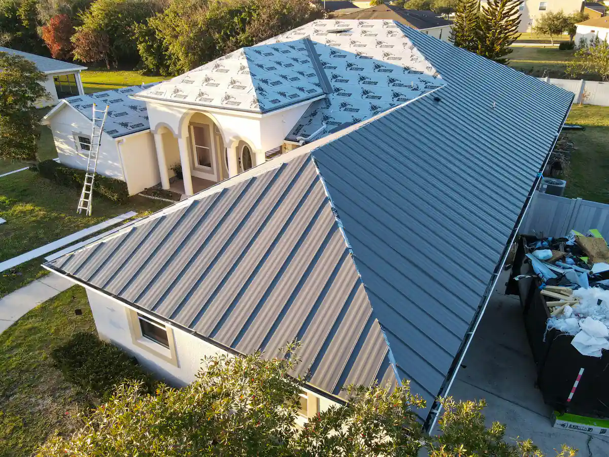 Grey standing seam panels going on over the right side of the Kissimmee roof