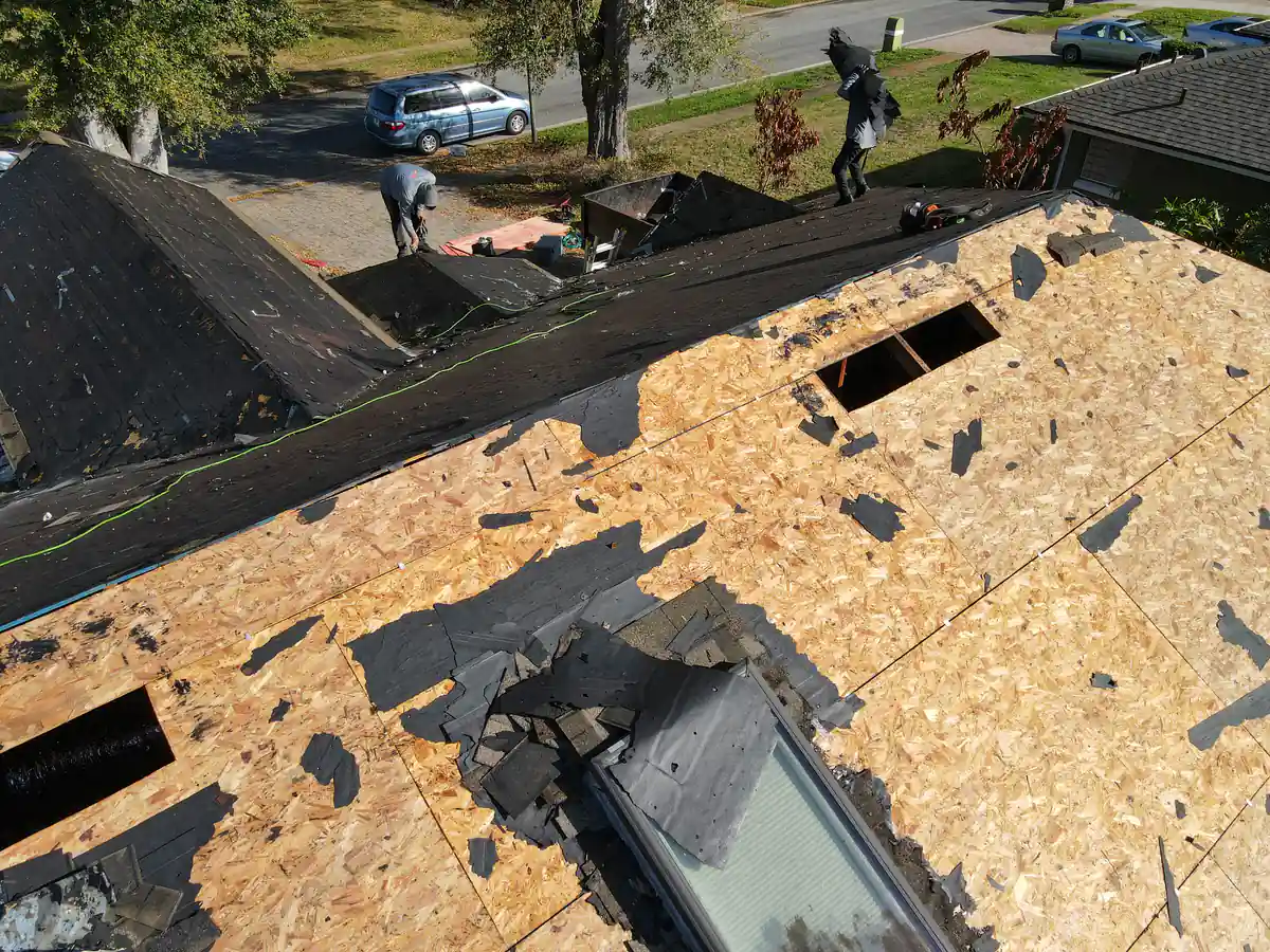 Half of the Orlando roof stripped to bare plywood while the other half still holds its old shingles