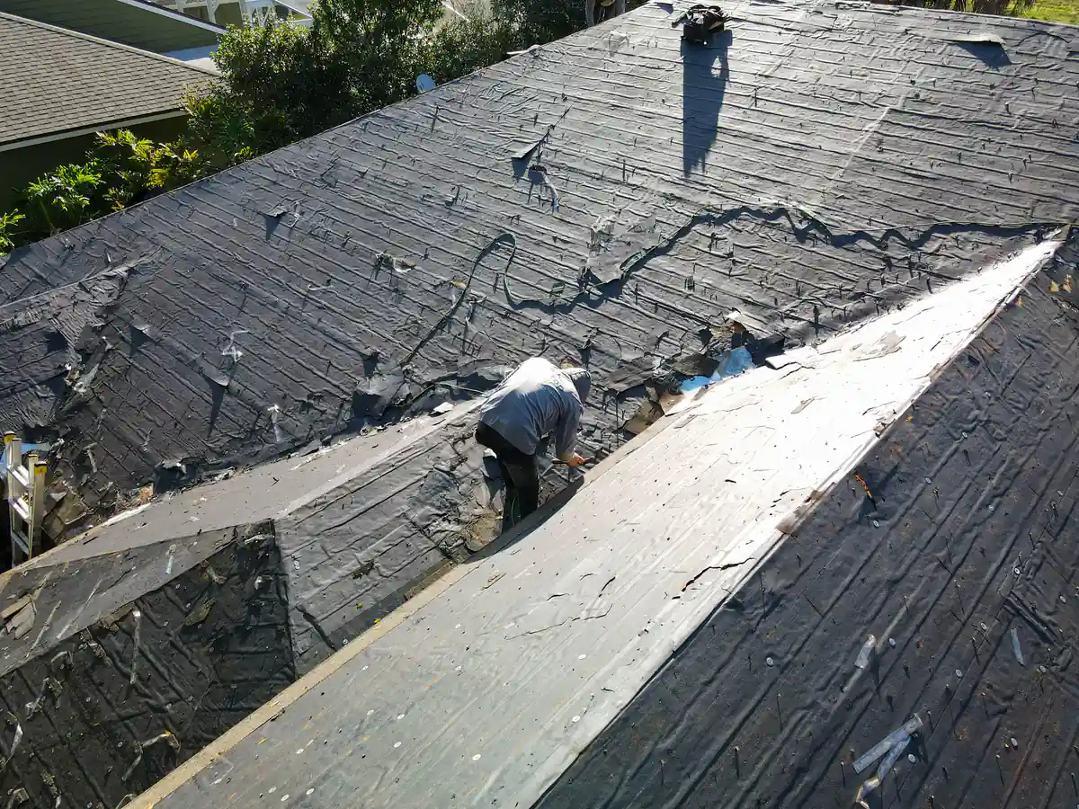 Roofer fastening new material down the middle of the stripped Orlando roof