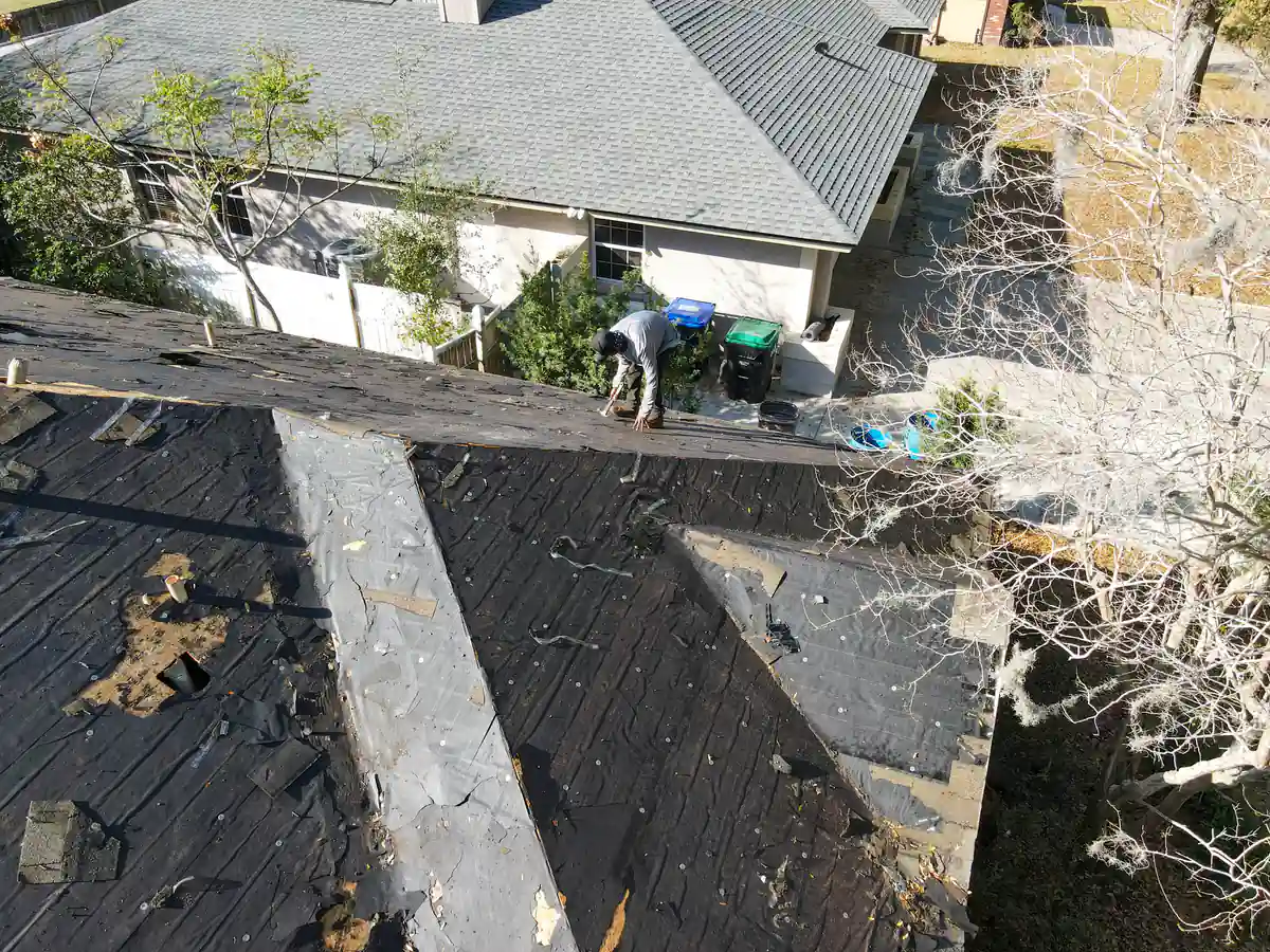 Roofer working the right slope of the Orlando roof next to the neighboring house