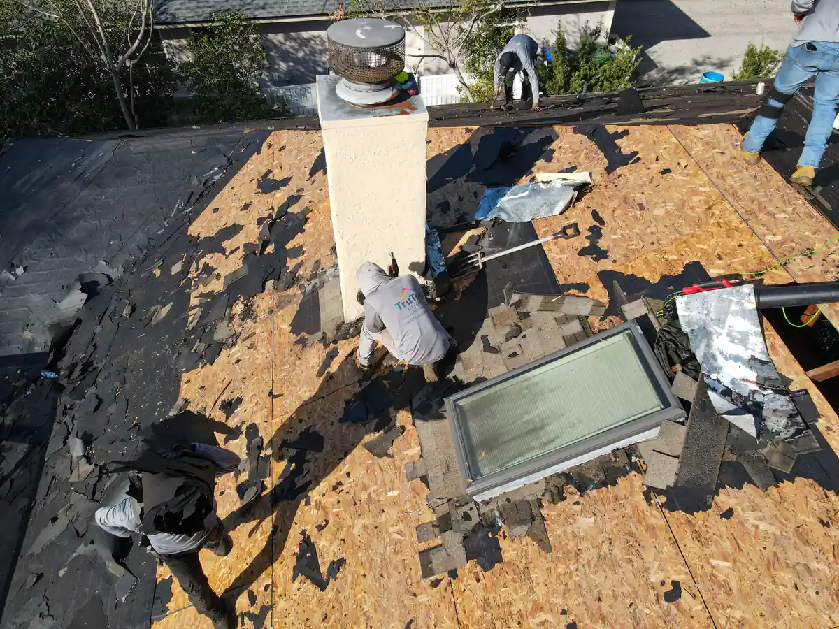TruTop Roof crew clearing the last of the old shingles around the chimney